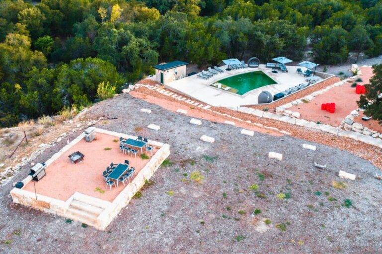 Drone view of pool and hilltop gathering space at Starlight Horizon cabins in Canyon Lake