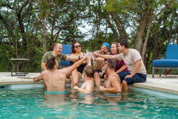 Guests Toasting Poolside at Starlight Horizon, a boutique cabin resort near Canyon Lake, Texas