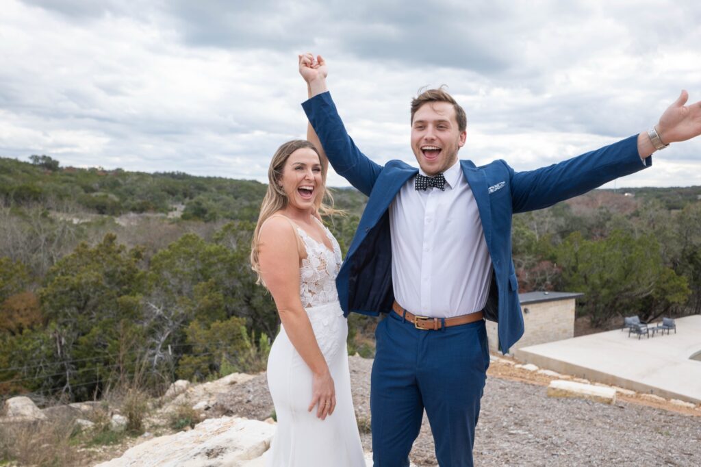 Bride and groom celebrating with raised arms at Starlight Horizon, a boutique cabin resort near Canyon Lake, Texas