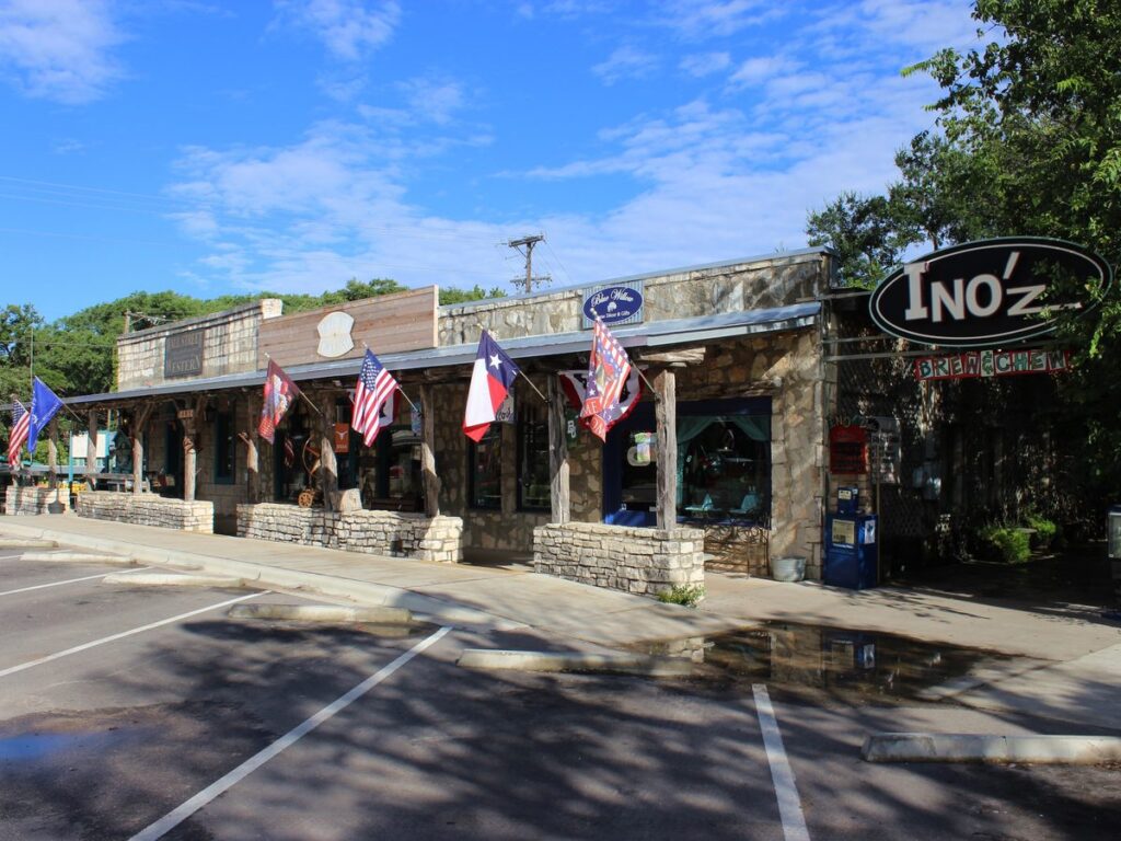 Stone storefronts and flags on the Wimberley Square in Wimberley Texas