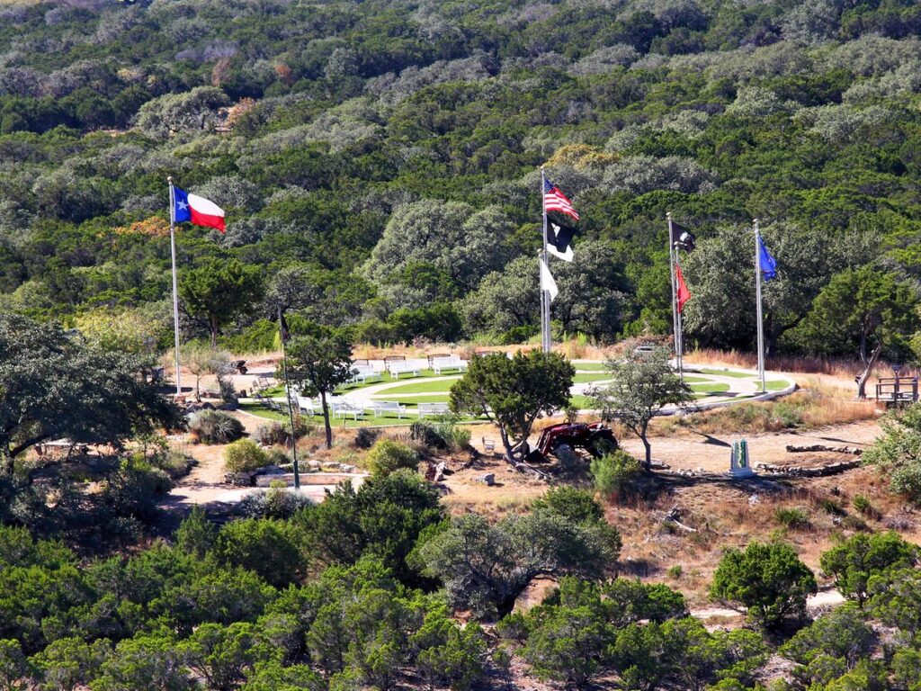 View over the Wimberley valley and EmilyAnn Veterans Plaza flags from Old Baldy