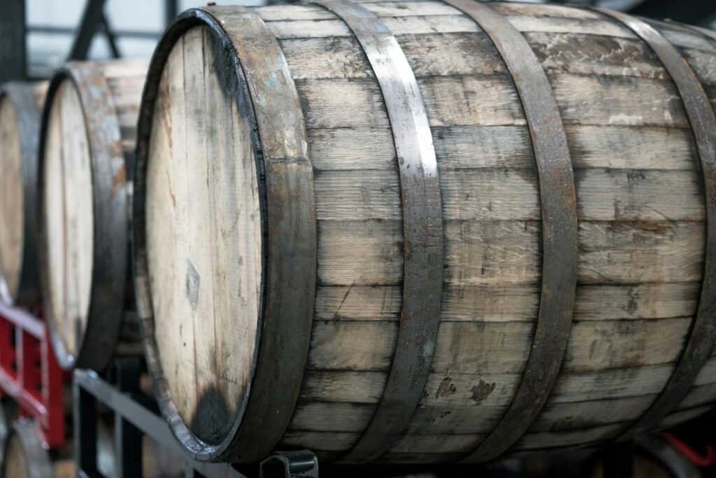 Stacked oak wine barrels with metal bands aging in a wine cellar