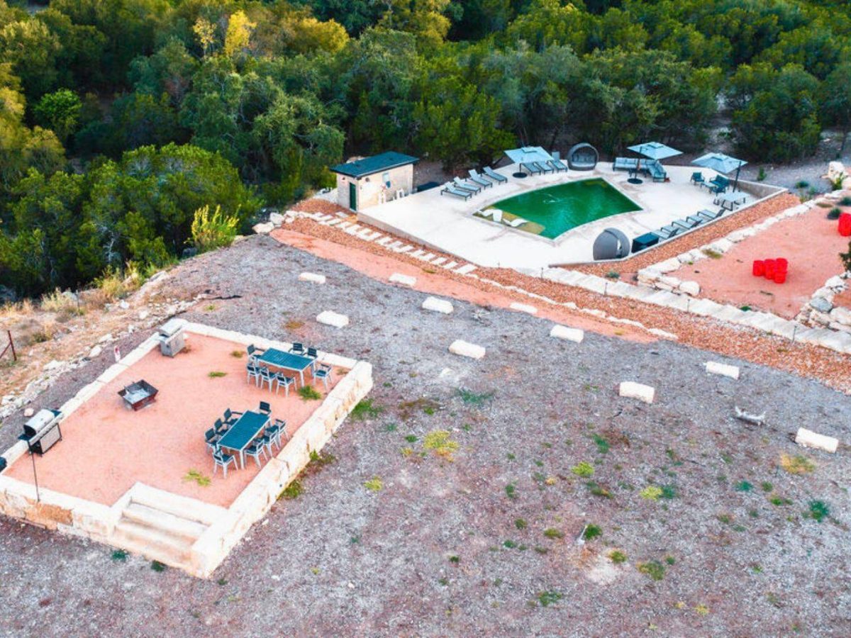 Drone view of pool and hilltop gathering space at Starlight Horizon cabins in Canyon Lake