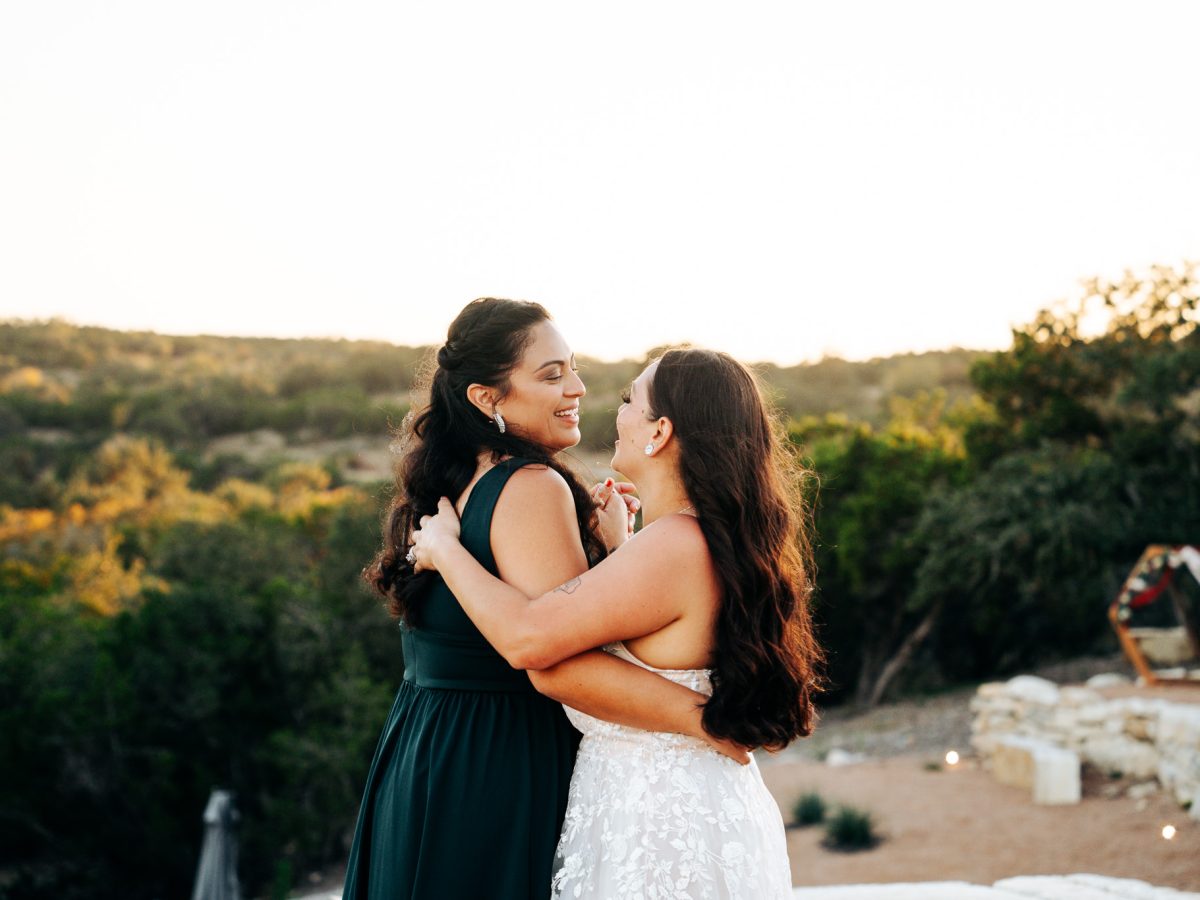 Two brides embracing at sunset at Starlight Horizon, a boutique cabin resort near Canyon Lake, Texas